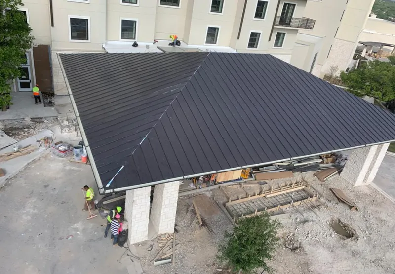 Metal roofing installation team working on a commercial building in New Haven